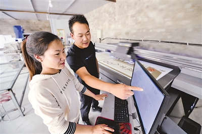 <p> 黎程云在UV喷绘机前指导同事操作设备。</p>