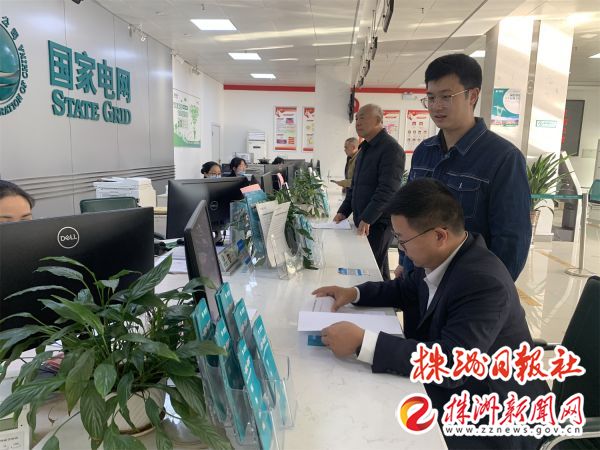 纪委负责人查看营业厅三零服务宣传资料