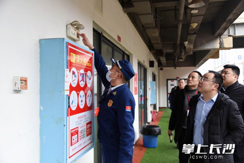 消防监督员查看应急照明等整改情况。