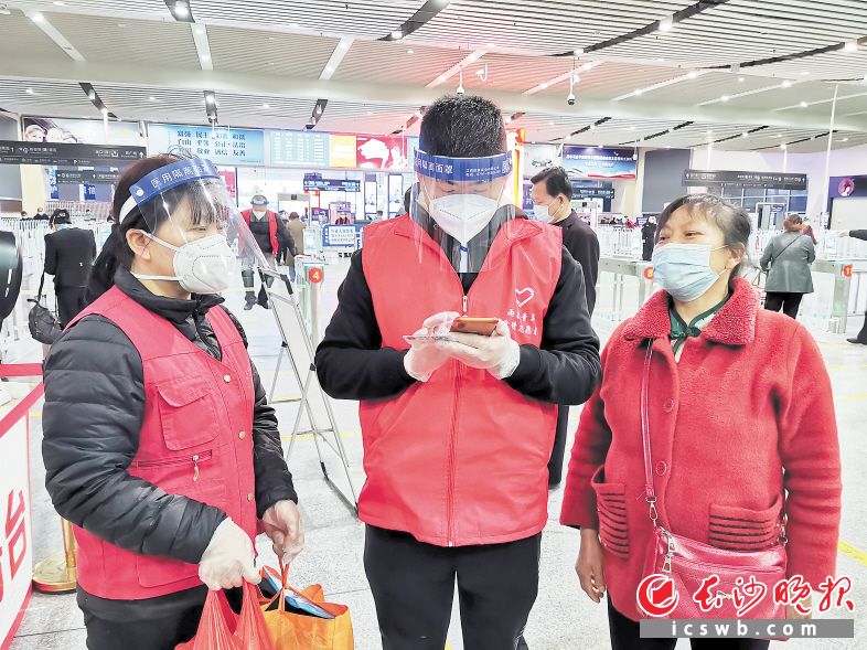 长沙火车南站站区内，志愿者正热心帮旅客申领健康码。　　长沙晚报通讯员 胡尚鹏 摄