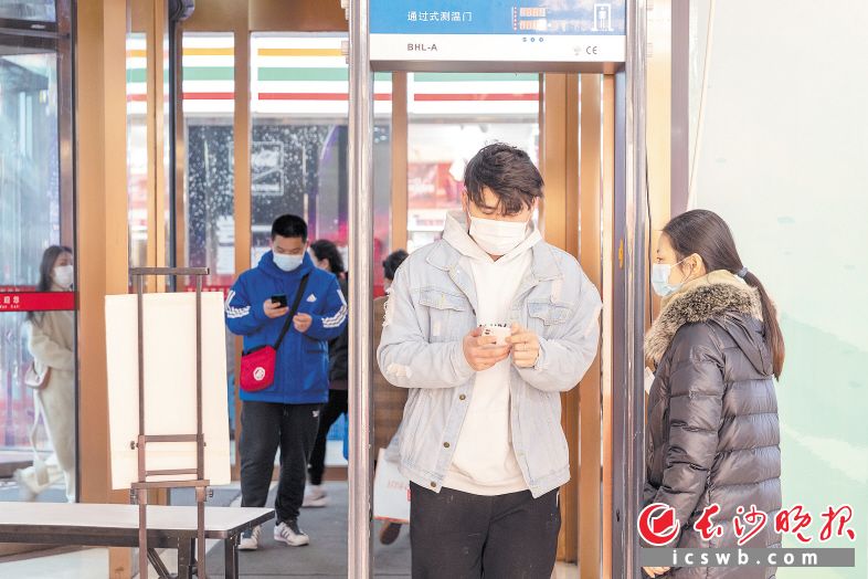 商超广场  20日，记者在万家丽国际购物广场看到，商场已增派专人值守各出入口，人员需佩戴口罩、测量体温、出示场所码才可进入。据工作人员金女士介绍，他们商场在第一时间里就增派人手加强风险防控，虽然天气转凉，但是她会和其他同事一样坚守岗位，请大家放心，大家一起加油。长沙晚报全媒体记者 董阳 摄