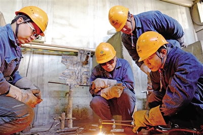 张立川（右一）为员工传授电焊技术。